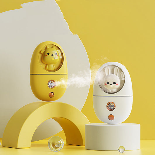 White egg-shaped portable facial humidifier with a pink cartoon rabbit inside a clear dome, gold nozzle and button. - Image 19