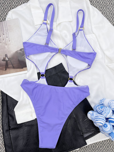 Purple one-piece swimsuit with front cut-outs and gold-tone O-ring details, modeled by a woman. - Image 5