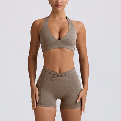 Light pink halter neck sports bra and high-waisted leggings workout set on a model. - Image 27