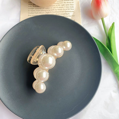 Clear plastic hair claw clip adorned with a single row of white faux pearls and a gold-toned spring. - Image 3