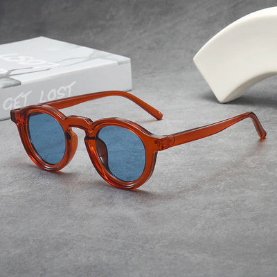 Vintage round frame sunglasses with black frames and pink lenses on a gray surface. - Image 5