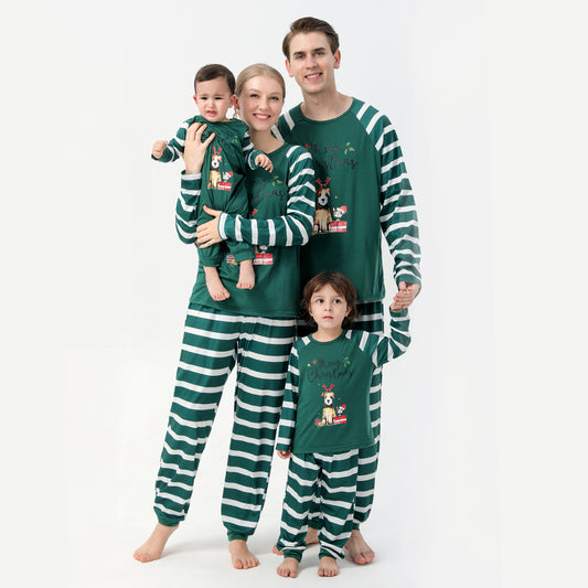 Woman in a Christmas pajama set with a white top, green sleeves, dinosaur graphic, and green fair isle pants.