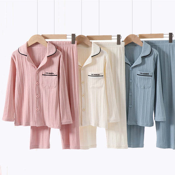 Beige ribbed cotton children's pajama set with long-sleeved lapel top and matching pants, featuring black trim.