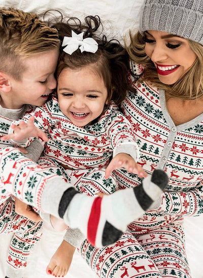 Family of four wearing matching white, red, and green fair isle Christmas pajamas with reindeer and snowflake patterns. - Image 15