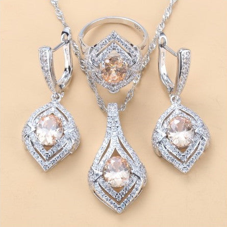 Silver-toned three-piece jewelry set with clear oval and round gems, including a necklace, dangle earrings, and a ring. - Image 14