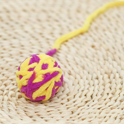 Colorful plush yarn ball cat toy in pink, blue, and white, with a long trailing strand, on a light background. - Image 41