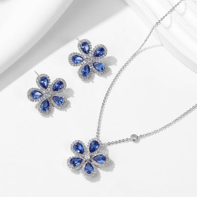 Elegant jewelry set with a silver-tone necklace and matching stud earrings, featuring blue and clear floral gemstones. - Image 6