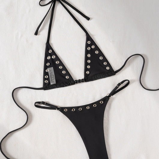Black tie-front bikini swimsuit with silver grommets on the triangle top and a ruched thong bottom, laid flat. - Image 4
