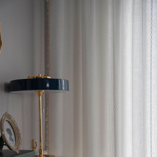 Black polyester curtain with white jacquard multi-line pattern and black tassels, draped over a white chair. - Image 31
