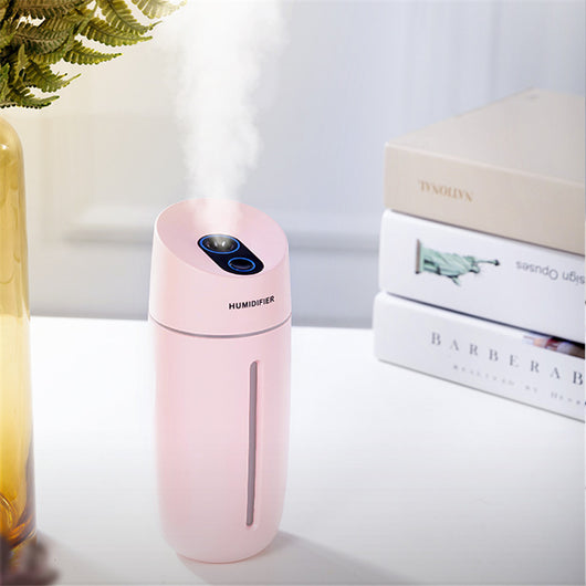 White desktop humidifier with blue LED light strip and control buttons, emitting mist on a wooden surface. - Image 5