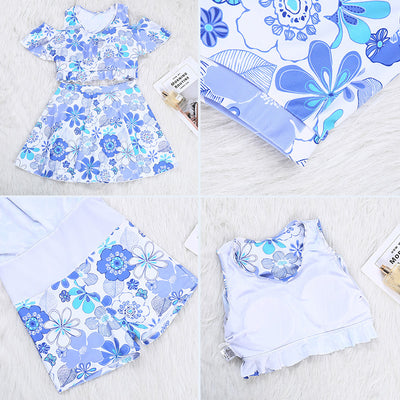 Two women in matching blue and white floral print swimsuits with off-shoulder ruffled tops and A-line skirts by the ocean. - Image 11