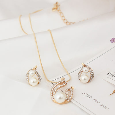 Gold-tone teardrop necklace and matching stud earrings set with white pearls and clear rhinestones, displayed on black. - Image 4