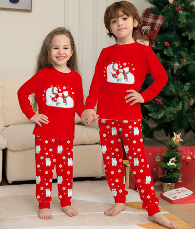 Young child wearing a red two-piece pajama set with a polar bear family graphic and snowflake print. - Image 4