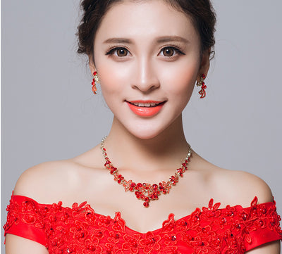 Red rhinestone bridal jewelry set featuring a floral necklace and matching dangle earrings on a model. - Image 6