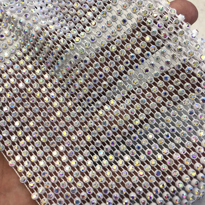 Close-up of a blue mesh fabric adorned with numerous small, clear rhinestones, creating a sparkling texture. - Image 5