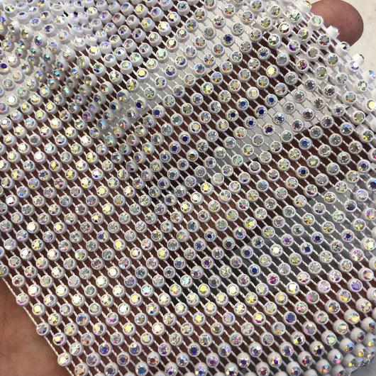 Close-up of a blue mesh fabric adorned with numerous small, clear rhinestones, creating a sparkling texture. - Image 5