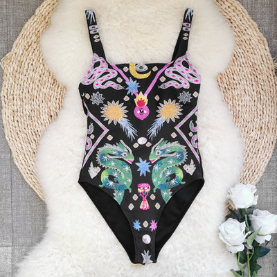 Black one-piece swimsuit for women featuring a vibrant multi-color print with dragons, suns, moons, and stars. - Image 4