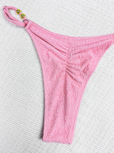 Pink textured halter bikini swimsuit with gold beads and a shell charm, worn by a woman on a wooden surface. - Image 15