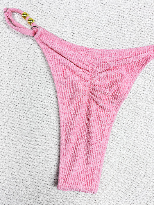 Pink textured halter bikini swimsuit with gold beads and a shell charm, worn by a woman on a wooden surface. - Image 15