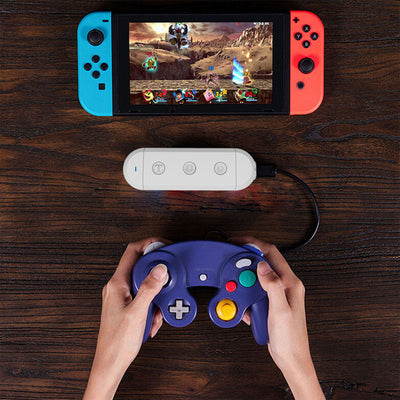 Gray wireless controller converter with GC Port, Wii Port, Micro USB, Turbo, Home, Capture, and Toggle buttons.
