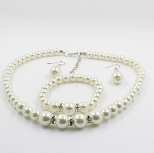 Off-white pearl necklace, matching drop earrings, and bracelet set with rhinestone accents for bridal wear. - Image 2