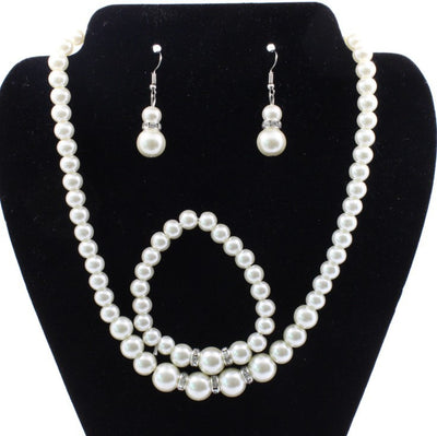 Off-white pearl necklace, matching drop earrings, and bracelet set with rhinestone accents for bridal wear. - Image 3