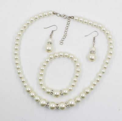 Off-white pearl necklace, matching drop earrings, and bracelet set with rhinestone accents for bridal wear.