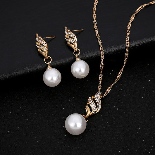 Gold-toned necklace and earring set with white faux pearls and clear rhinestones in a wavy design. - Image 6