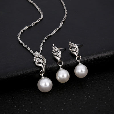 Gold-toned necklace and earring set with white faux pearls and clear rhinestones in a wavy design. - Image 7