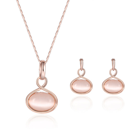 Rose gold necklace and matching drop earrings set with oval light pink cabochon stones.