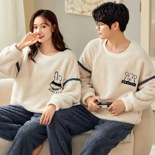 Couple wearing matching cream coral fleece pajamas with gray pants and bear embroidery, seated on a bed. - Image 10