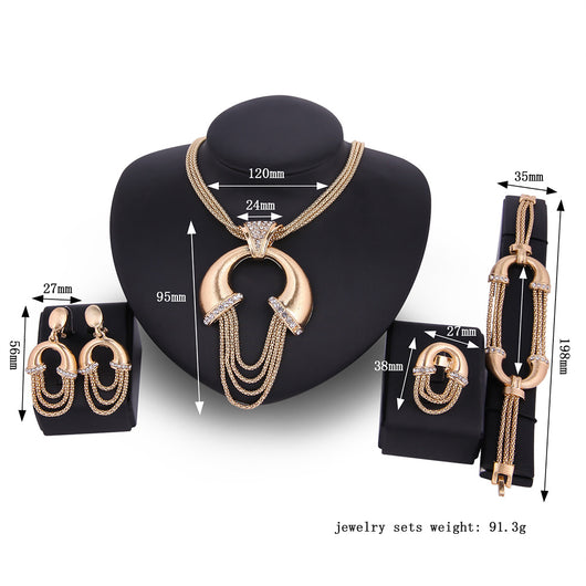 Four-piece gold-tone bridal jewelry set with crystal accents, including a statement necklace, dangling earrings, bracelet, and ring. - Image 3