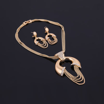 Four-piece gold-tone bridal jewelry set with crystal accents, including a statement necklace, dangling earrings, bracelet, and ring. - Image 5