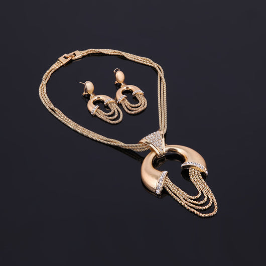 Four-piece gold-tone bridal jewelry set with crystal accents, including a statement necklace, dangling earrings, bracelet, and ring. - Image 5