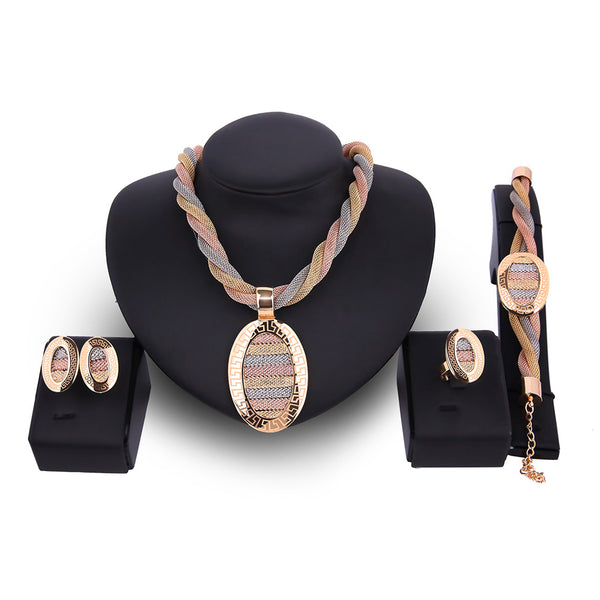 Four-piece jewelry set with tri-color braided necklace, earrings, bracelet, and ring. Each piece features an oval design with a Greek key border and striped gol