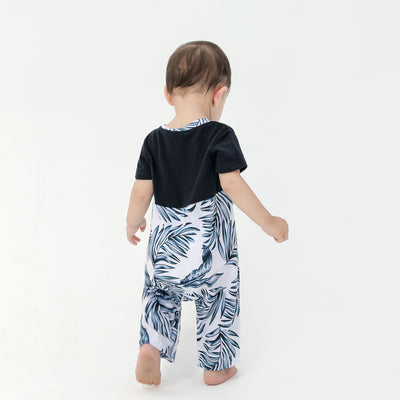 Young boy wearing a white short-sleeve t-shirt with blue tropical leaf print and a black chest pocket. - Image 17