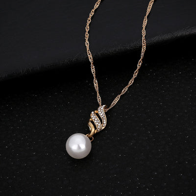 Gold-toned necklace and earring set with white faux pearls and clear rhinestones in a wavy design. - Image 4