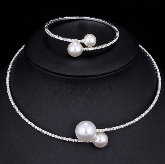 Elegant silver-tone choker necklace with a single row of clear rhinestones and two white faux pearls of varying sizes.