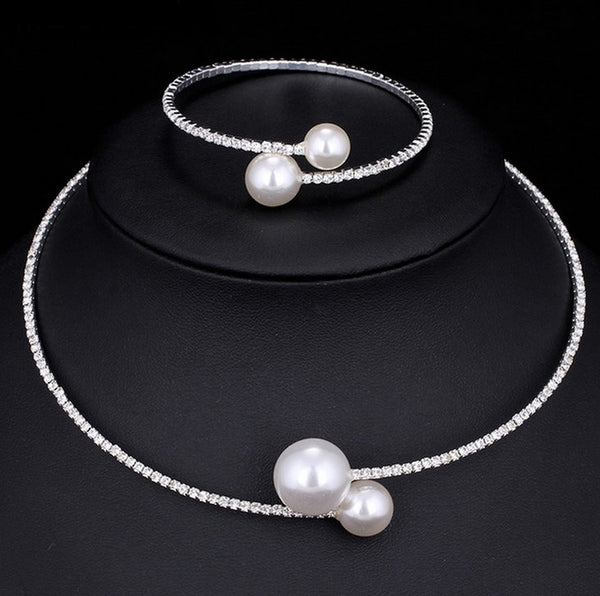 Elegant silver-tone choker necklace with a single row of clear rhinestones and two white faux pearls of varying sizes.