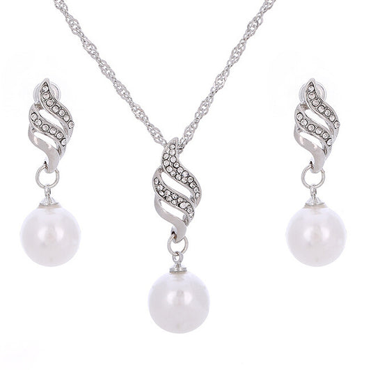 Gold-toned necklace and earring set with white faux pearls and clear rhinestones in a wavy design. - Image 2