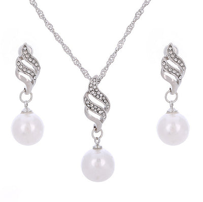 Gold-toned necklace and earring set with white faux pearls and clear rhinestones in a wavy design. - Image 2