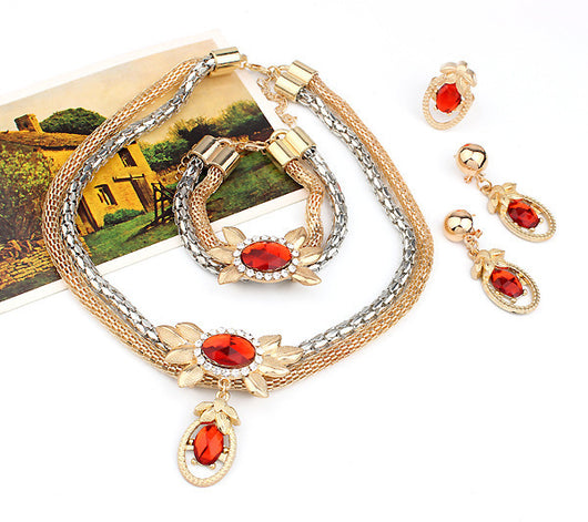 Bridal four-piece jewelry set with a two-tone necklace, bracelet, earrings, and ring, featuring red crystal flower designs.