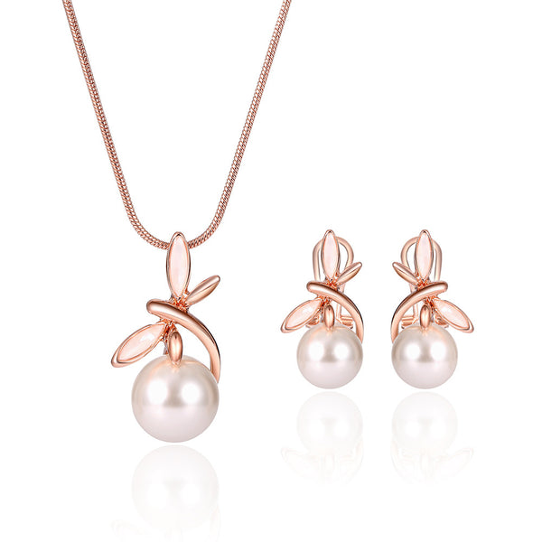 Rose gold-toned necklace and matching earrings set with white pearls and a delicate floral or leaf design.