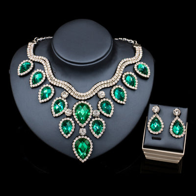 Colorful exaggerated bride necklace and earring set with large teardrop rhinestones on a dark display. - Image 17