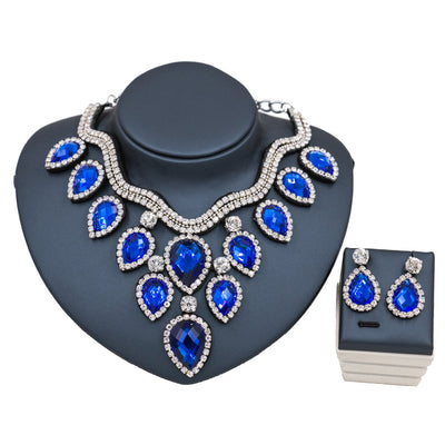Colorful exaggerated bride necklace and earring set with large teardrop rhinestones on a dark display. - Image 13