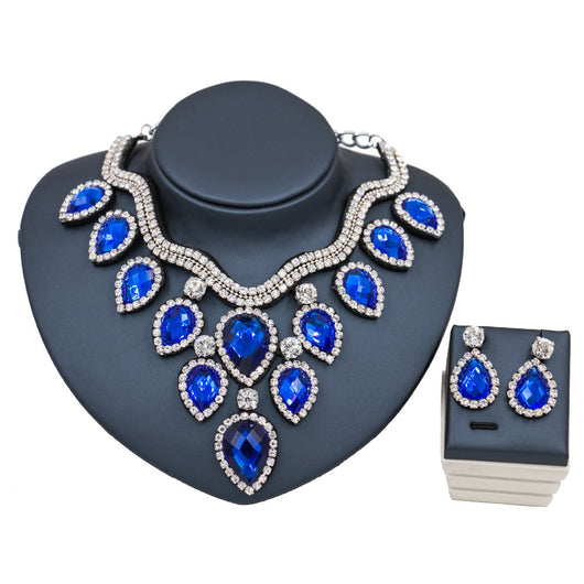 Colorful exaggerated bride necklace and earring set with large teardrop rhinestones on a dark display. - Image 13