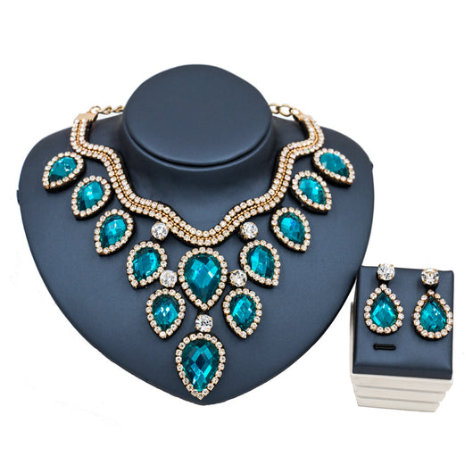 Colorful exaggerated bride necklace and earring set with large teardrop rhinestones on a dark display. - Image 3