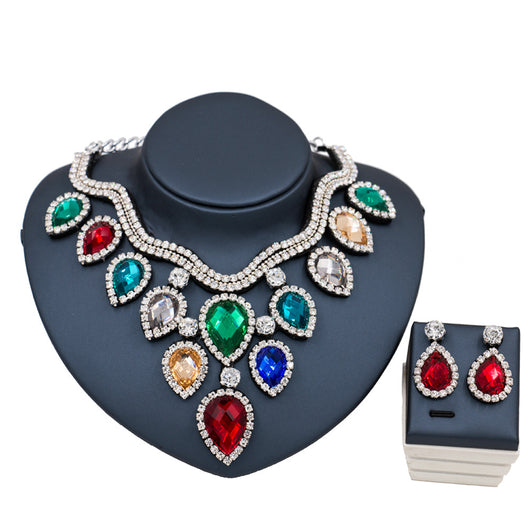 Colorful exaggerated bride necklace and earring set with large teardrop rhinestones on a dark display. - Image 10