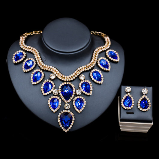 Colorful exaggerated bride necklace and earring set with large teardrop rhinestones on a dark display. - Image 14