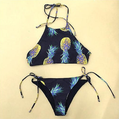 Black halter neck bikini top and tie-side bottoms with a vibrant yellow and green pineapple print. - Image 3